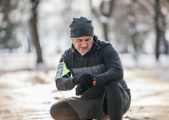 Senior biegając w zimie monitoruje swoje ciśnienie na smartwatchu dla seniora z funkcją mierzenie ciśnienia