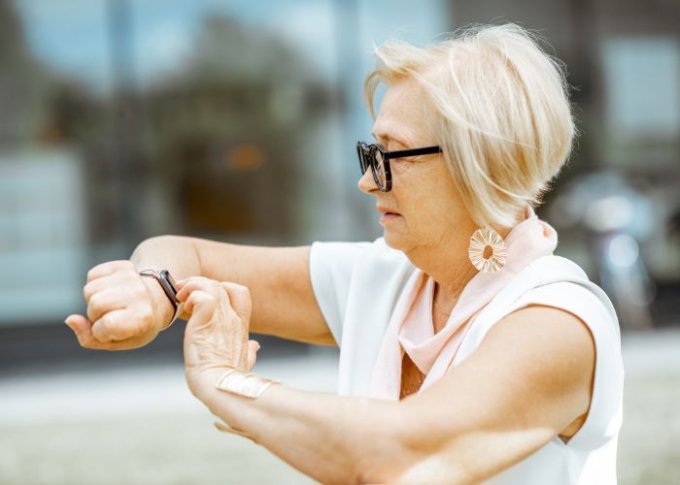 Kobieta sprawdza ciśnienie na smartwatchu dla seniora z ciśnienimierzem