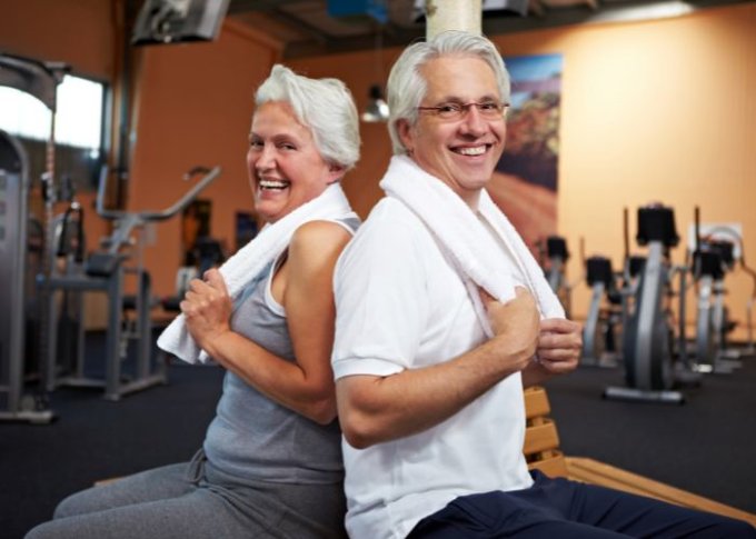 Para seniorów wspólnie ćwiczy na siłowni