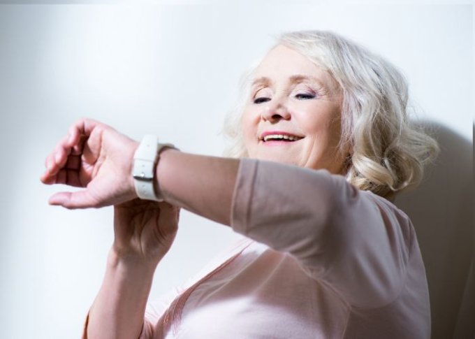 Seniorka sprawdza funkcje zdrowotne w smartwatchu damskim dla seniora
